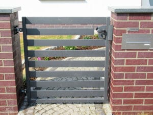 Graues Gartentor bei Ziegelsteinmauer mit Briefkasten