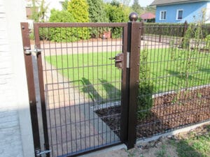 Braunes Gartentor mit Metallzaun und Rasen.