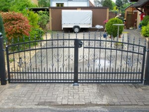 Schmiedeeisernes Tor vor Einfahrt mit Anhänger.