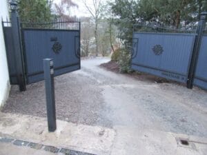 Offene Einfahrtstore mit unbefestigtem Weg.