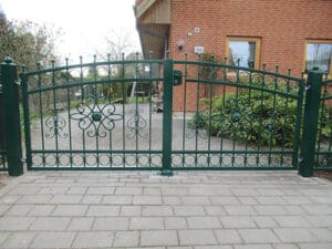 Grünes schmiedeeisernes Tor vor einem Haus.