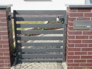 Gartentor aus Metall an Ziegelsteinsäule.