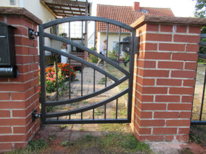 Ziegelsteinsäulen mit schwarzem Metallgartenzaun.