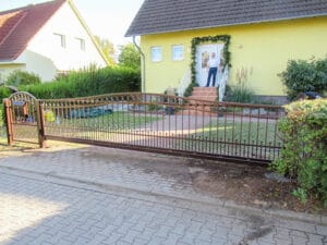 Hausfront mit Zaun und Eingangstor.