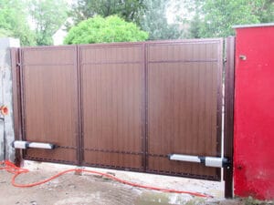 Braunes Schiebetor mit Antrieb im Außenbereich.