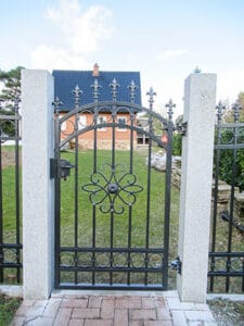 Gartentor aus Metall vor einem Einfamilienhaus.