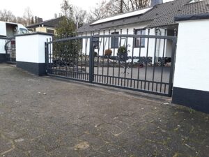 Eisernes Tor vor einem weißen Haus.