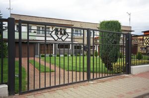 Einfamilienhaus mit Metalltor und gepflegtem Garten.
