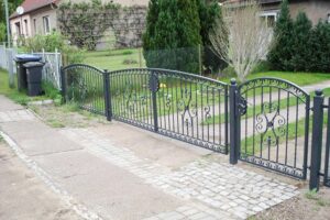 Metallenes Gartentor und Zaun mit Einfahrt.