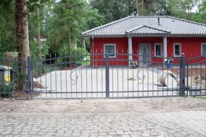 Rotes Haus mit Zaun und Einfahrt