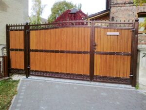 Braunes Holztor mit Metallverzierungen an Einfahrt