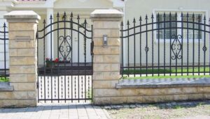 Elegantes schmiedeeisernes Gartentor mit Steinpfosten.