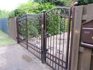 Schmiedeeisernes Tor mit Verzierungen und Briefkasten.