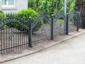 Eiserner Zaun vor einem Wohnhaus.