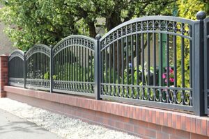 Schmiedeeisernes Gartentor mit Ziegelmauer.