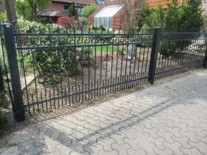 Metallzaun vor einem Wohnhaus.