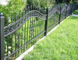 Schmiedeeiserner Gartenzaun im Grünen.