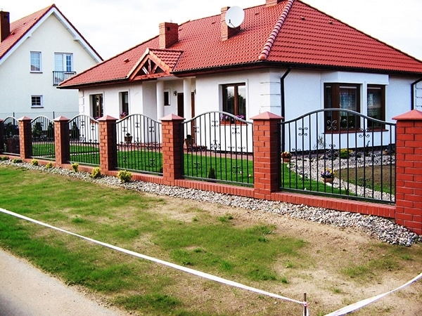 Einfamilienhaus mit rotem Dach und Zaun in Deutschland.