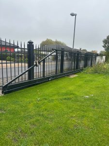 Elegantes automatisches Schmiedeeisentor mit dekorativen Spitzen, hergestellt von Komabud – stabile und langlebige Schmiedezäune .