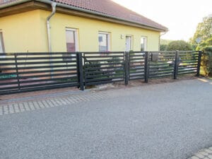 Haus mit modernem Metallzaun und Einfahrt