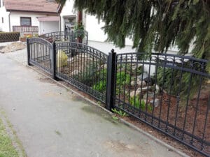 Schmiedeeisernes Gartentor und Zaun vor einem Haus