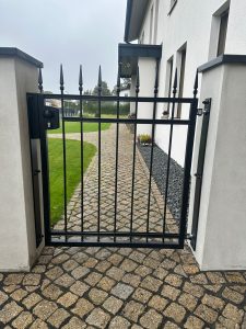 Klassisches Schmiedeeisentor mit dekorativen Spitzen, handgefertigt von Komabud – langlebiger Schmiedeeisenzaun .