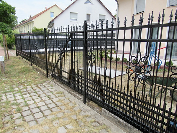 Schmiedeeisernes Tor bei Einfahrt und Gartenzaun.