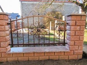 Eisernes Gartentor mit Ziegelsteinpfeilern.