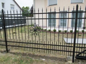 Schmiedeeisernes Gartentor und Zaun mit Verzierungen.