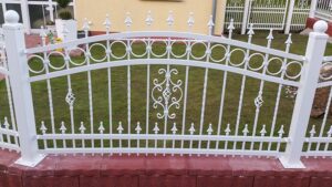 Weißes Ziergitterzaun vor einem Garten