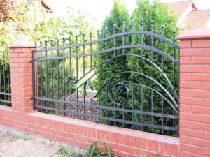 Schmiedeeisernes Tor mit Ziegelsteinmauer.