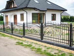 Weißes Haus mit schmiedeeisernem Zaun.