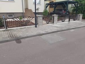 Eingang mit schmiedeeisernem Zaun und Auffahrt