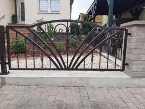 Dekoratives Gartentor aus Schmiedeeisen mit Steingarten.