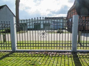 Eisernes Tor vor einem Gebäude im Sonnenlicht.