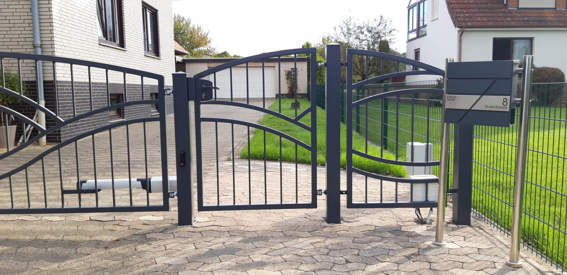 Metalltor Einfahrt Einfamilienhaus mit Briefkasten.