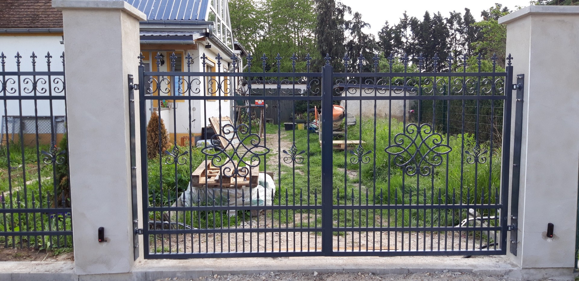 Schmiedeeisernes Tor vor einem privaten Garten.