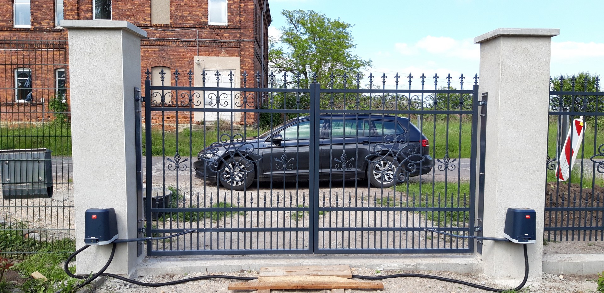 Schmiedeeisernes Tor vor historischem Gebäude.