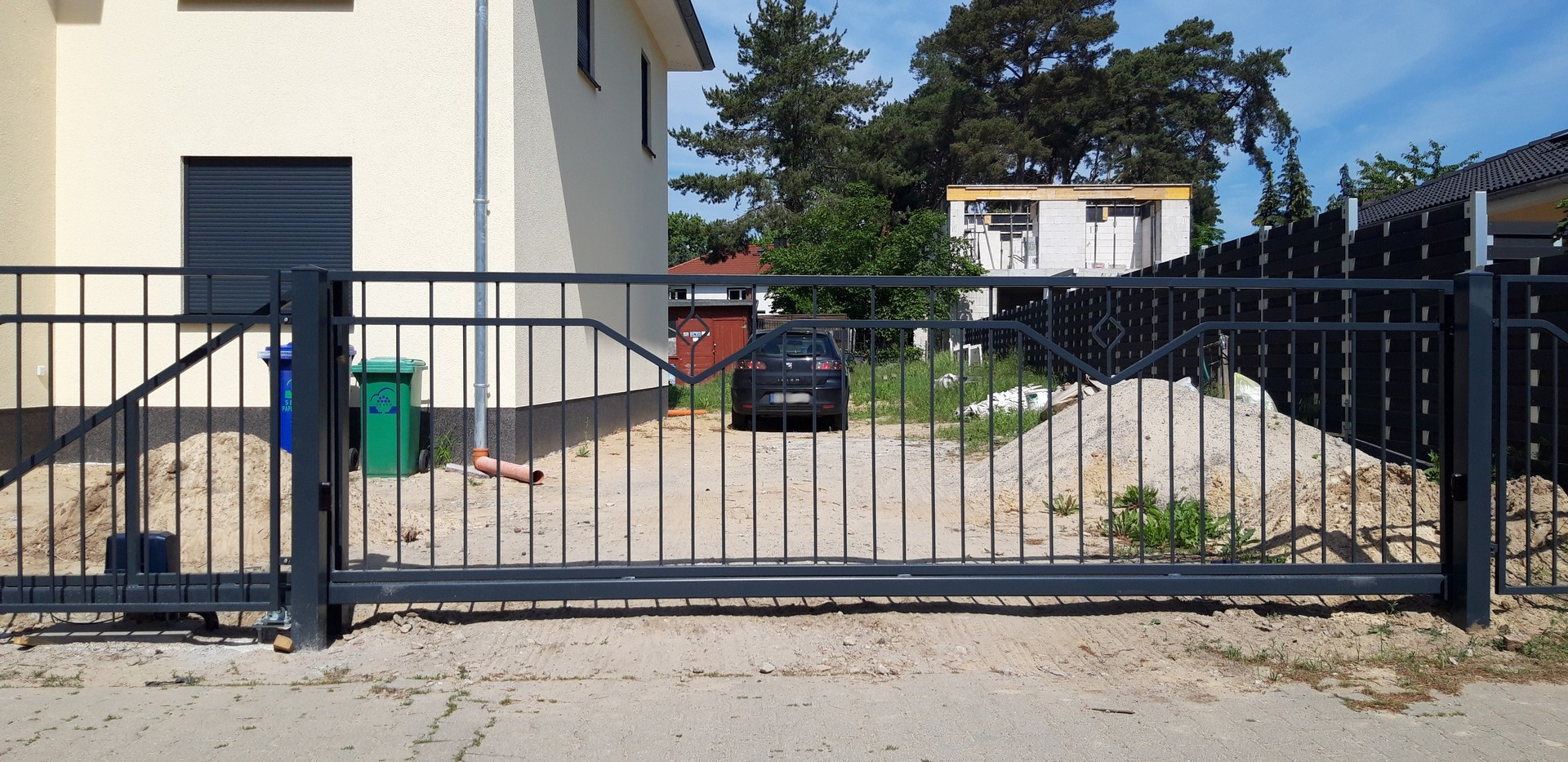 Metalltor, Bauarbeiten im Hinterhof, Auto parkt.