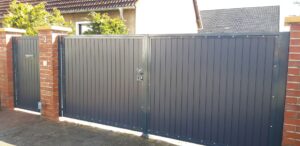 Graues Metalltor an einem Einfamilienhaus.