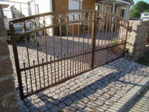 Schmiedeeisernes Tor vor einem Einfamilienhaus.