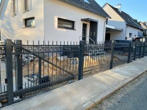 Einfamilienhaus mit schwarzem Metallzaun in Deutschland.