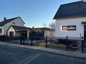 Zwei Häuser mit Carport bei Sonnenuntergang.