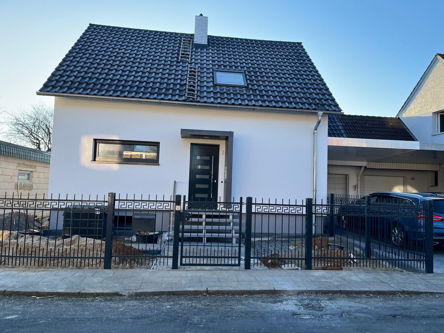 Einfamilienhaus mit Zaun und Carport in Deutschland.