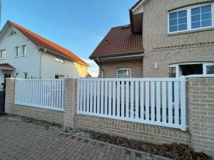 Moderne Einfamilienhäuser mit weißem Zaun.