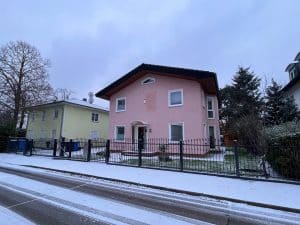 Rosa Haus mit Schnee und Garten im Winter