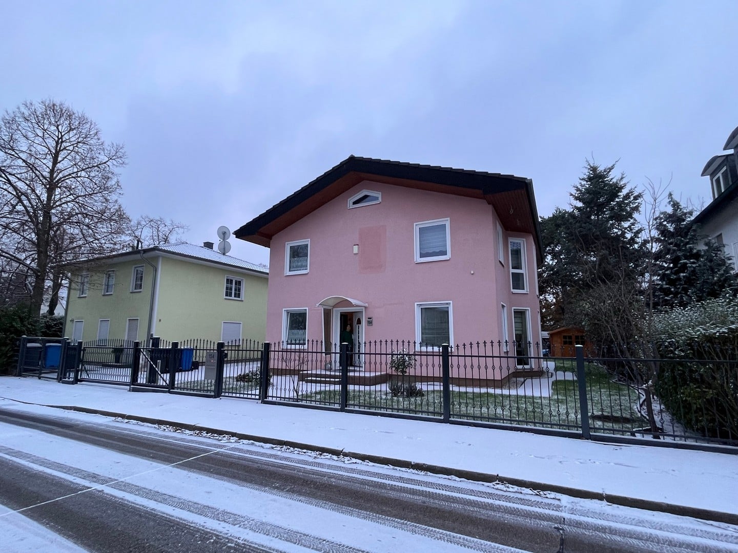 Rosa Haus mit Schnee und Garten im Winter