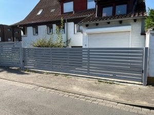 Graues Metalltor vor Einfamilienhaus.