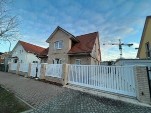 Einfamilienhaus mit Ziegelmauer und weißem Zaun