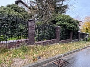 Verziertes Eisentor und Mauer mit Efeu.